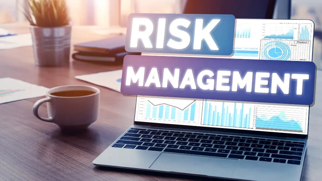 A laptop with the words 'risk management' across the screen'