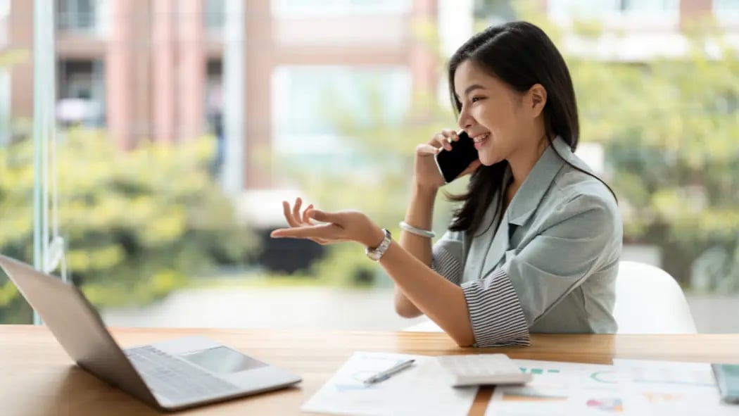 Woman sat in office on the phone