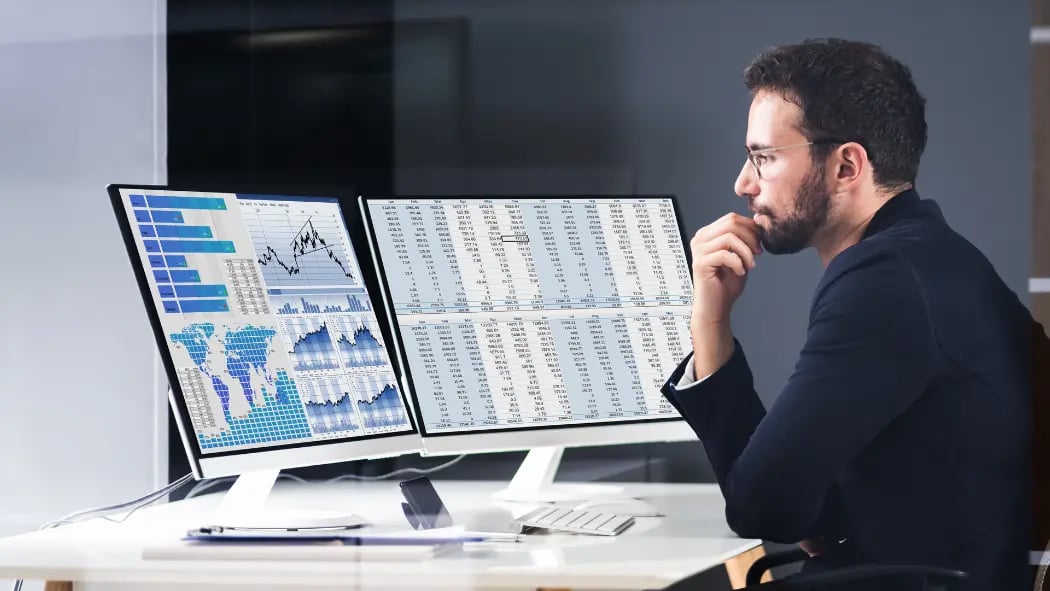 Man sat at desk looking at data on computer screen