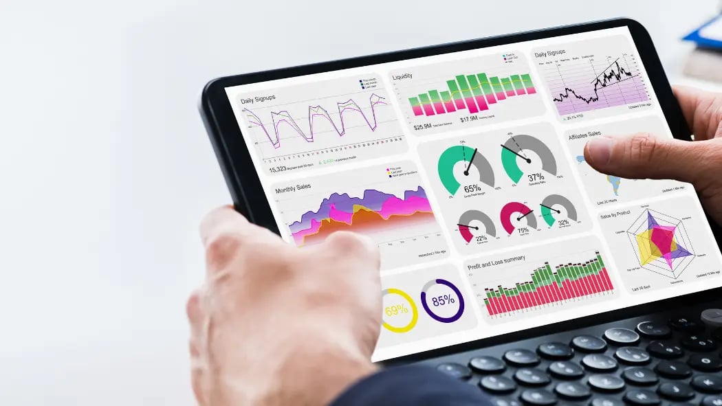 Hands holding a tablet that show visuals of data graphs