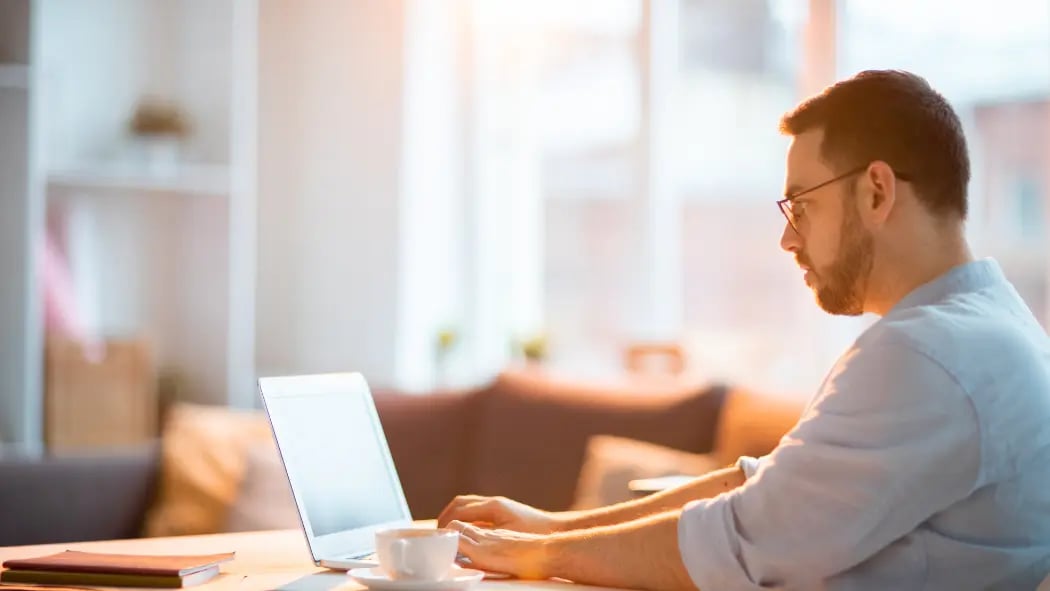 Man sat at home on his laptop