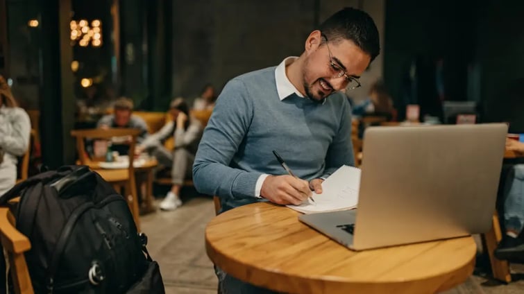 A man working at a laptop in a cafe