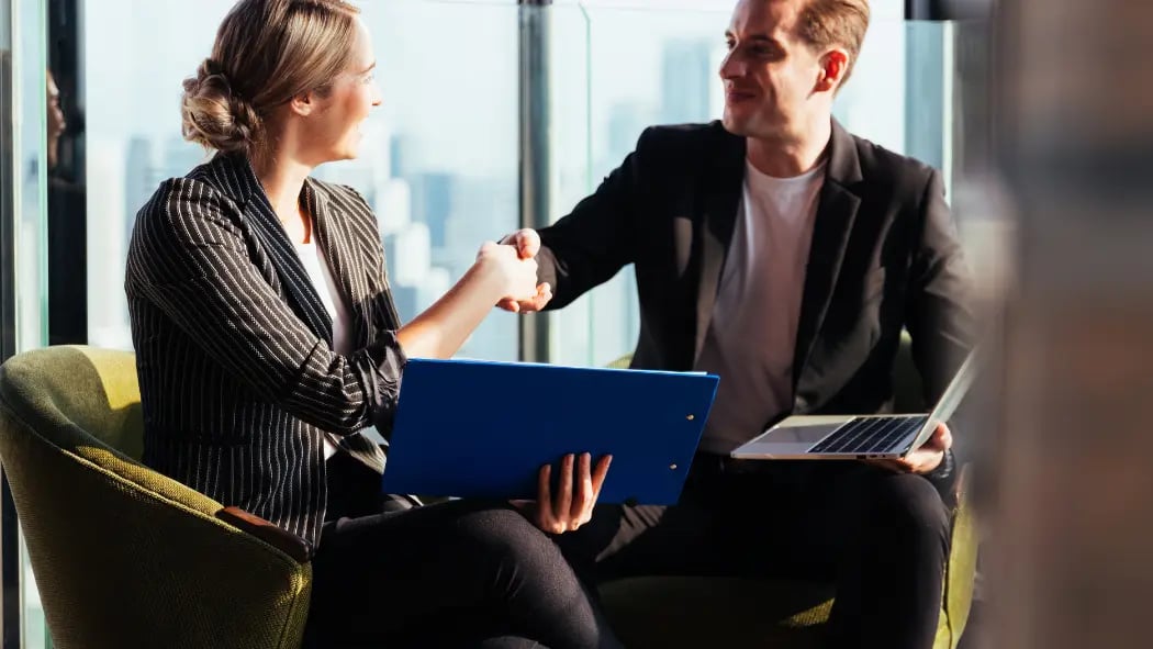 Two people at work shaking hands