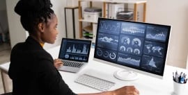 A young black woman viewing charts and graphs on a computer screen