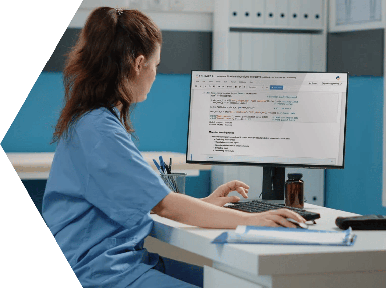 Female clinician sat at a desk with a computer showing the EDUKATE.AI learning platform on the screen