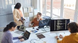 People in an office working at desks grouped together