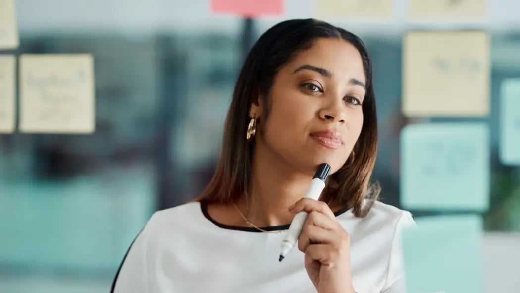 Woman sat in office environment thinking