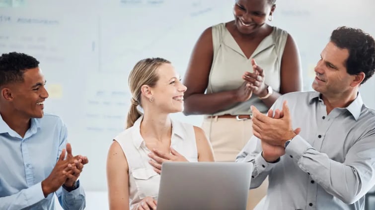 Happy staff at work clapping another member of staff