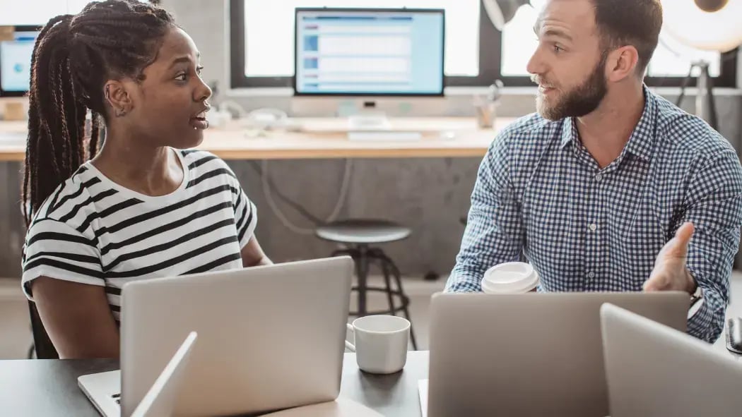 Two people talking in an office environment 