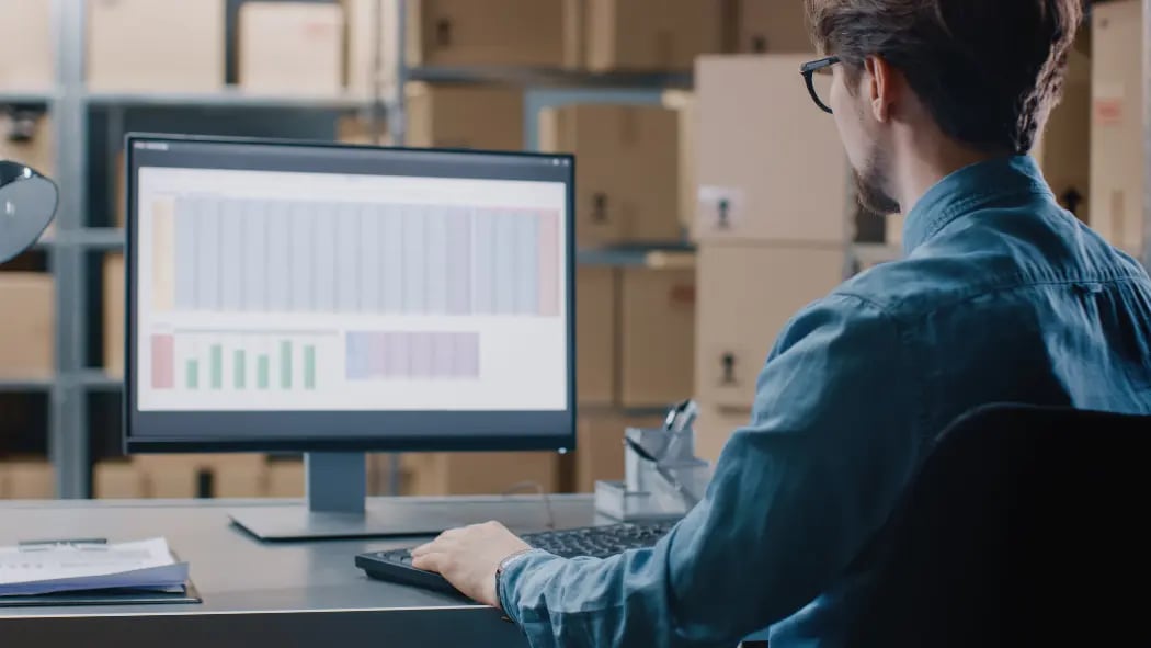 man sat at computer with data on the screen