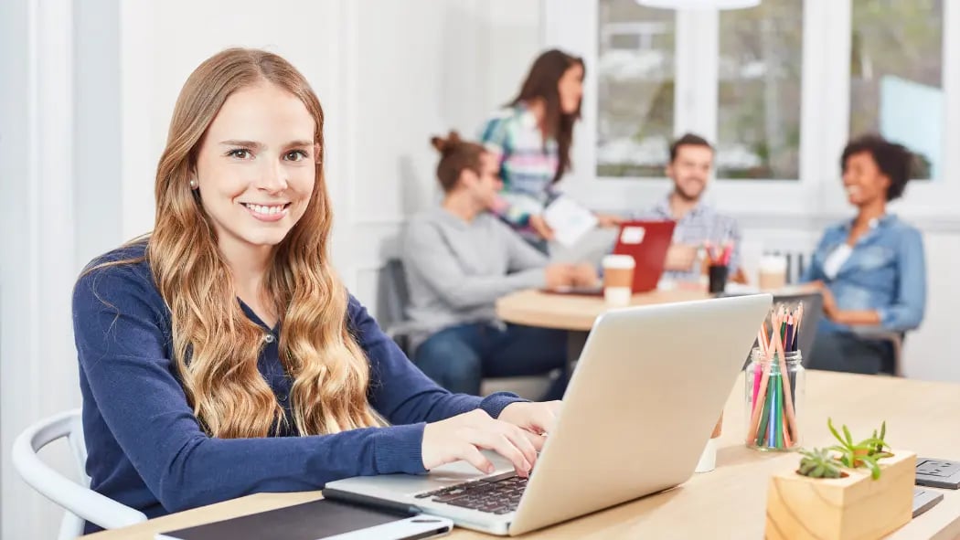 A woman sat at a laptop smiling