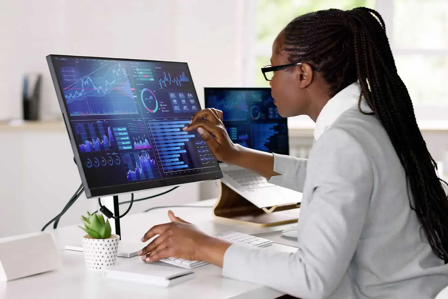 Woman looks at computer screen with graphs