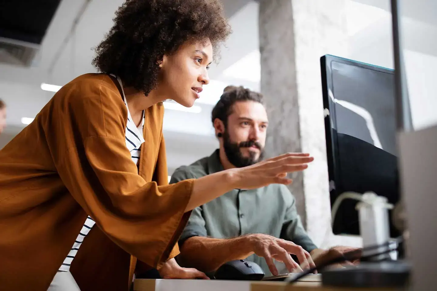 Digital product manager guiding someone on a computer